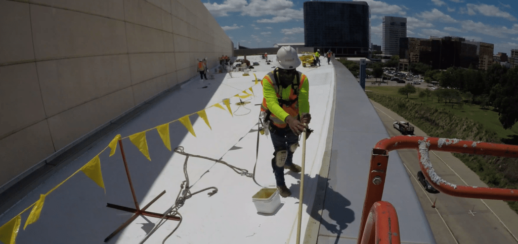 Roofer installing white commercial roof.