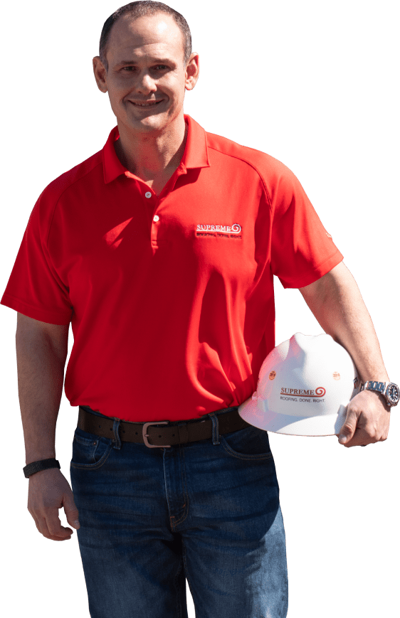 Man holding hardhat with supreme roofing logo on it.