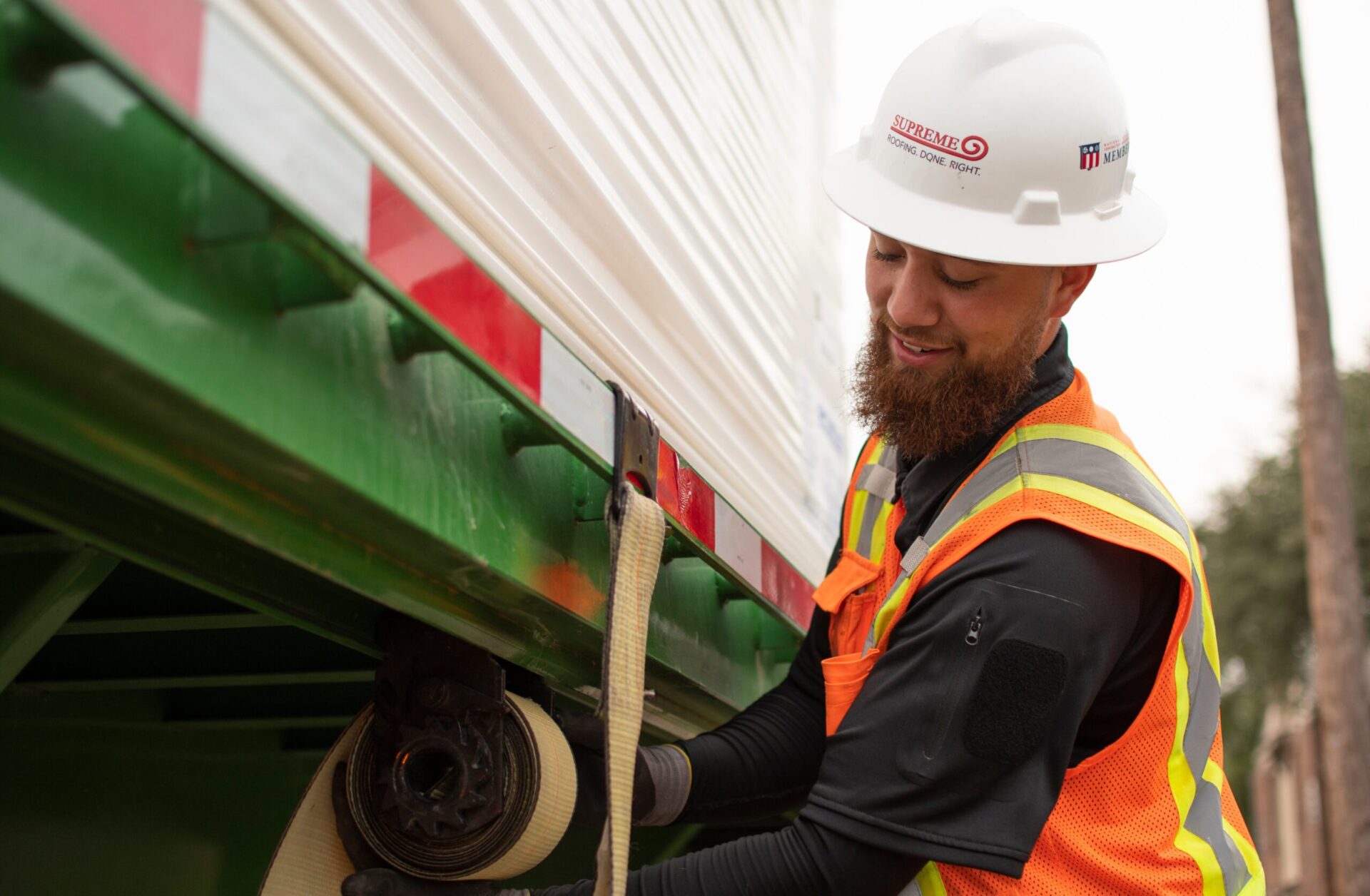 Man tying down material on truck.